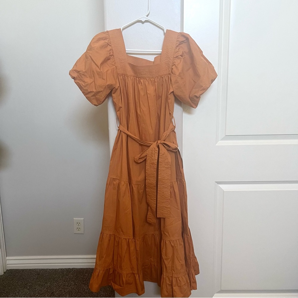 Orange, tiered, small women’s dress. Square neck, bow, and poofy sleeves.